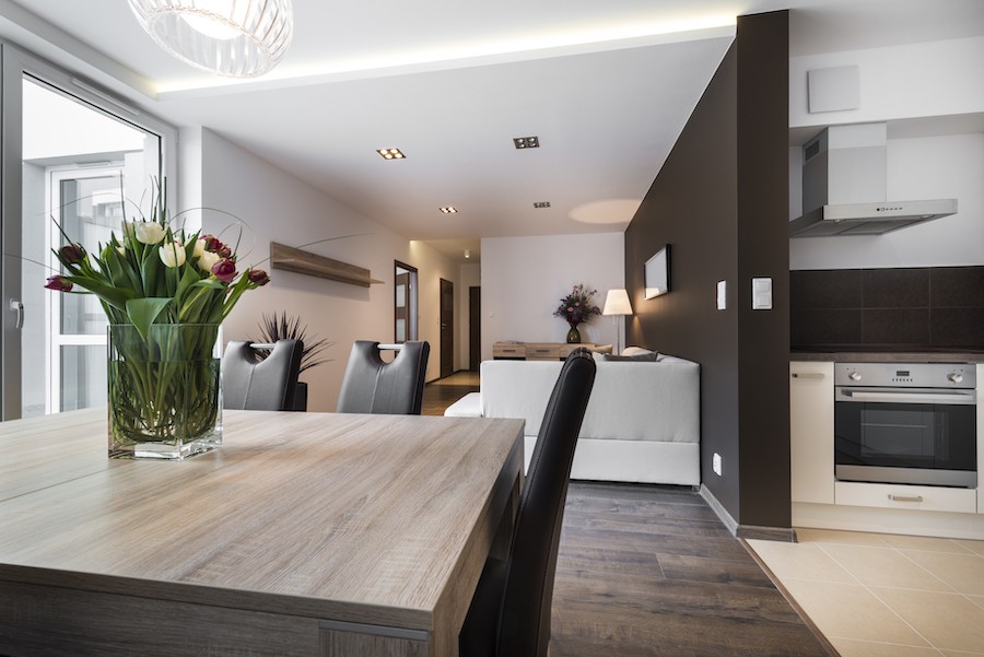 A dining and living room space featuring in-ceiling smart lighting control fixtures.